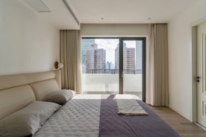 A modern bedroom with a large bed, a view of tall buildings, and a sliding glass door. - Spacious 3-bedroom apartment with high floor view and 3 balcony (Shanghai)