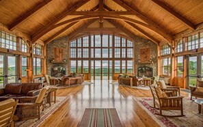 Una habitación amplia con techo alto, ventanas grandes y chimenea.