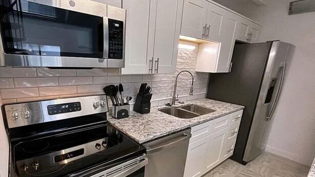A kitchen with stainless steel appliances, a granite countertop, and white cabinetry. - Whistlepunk #43: 1 Bedroom With Loft, Slopeside (Snowshoe)