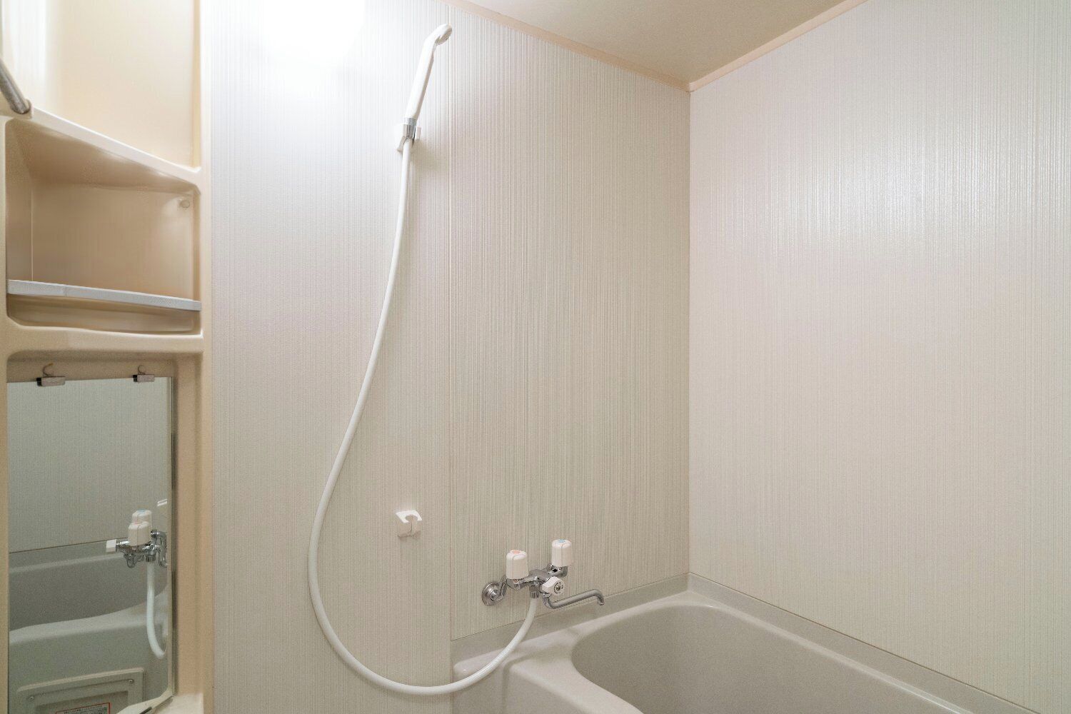 Une salle de bain avec une baignoire, une douche et un miroir.