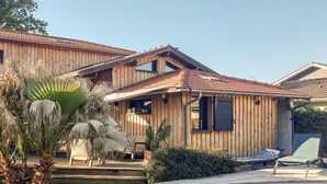 A wooden house with a swimming pool, a patio, and a garden with palm trees. - Superbe maison avec piscine (Andernos-les-Bains)