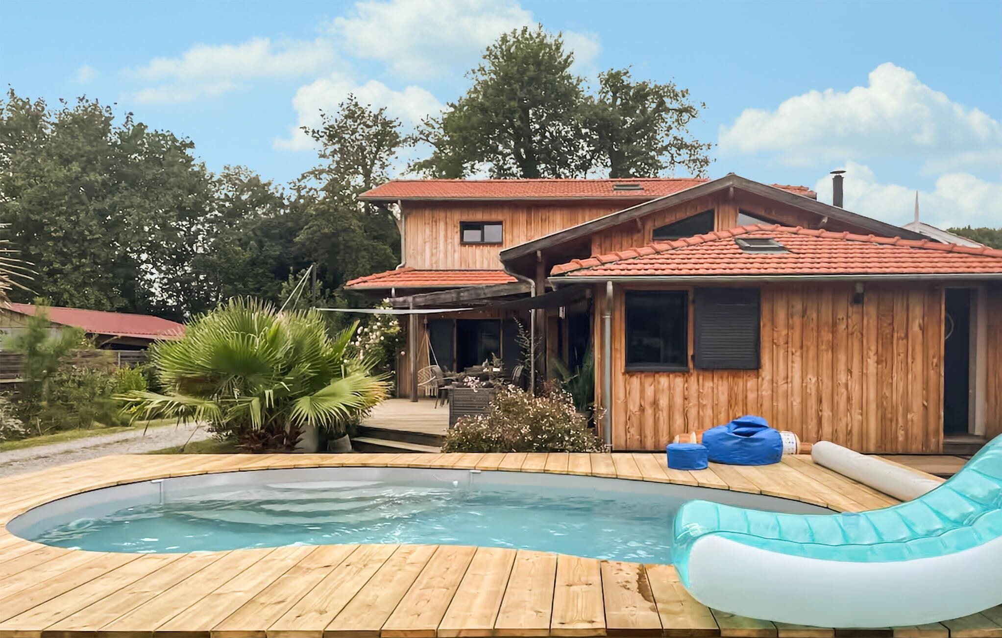 Une maison en bois avec une piscine, un jacuzzi et un toboggan.