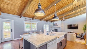 A modern kitchen with a large island, pendant lighting, and a dining area with a view. - Luxury 6 Bed Scottsdale Retreat w/ Pool (Scottsdale)