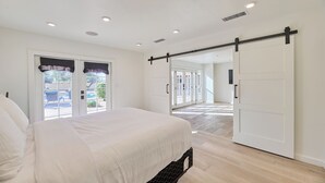 A bedroom with a bed, a sliding door, and a view through the door to an outdoor area. - Luxury 6 Bed Scottsdale Retreat w/ Pool (Scottsdale)