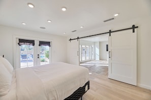 A bedroom with a bed, a sliding door, and a view through the door to an outdoor area. - Luxury 6 Bed Scottsdale Retreat w/ Pool (Scottsdale)
