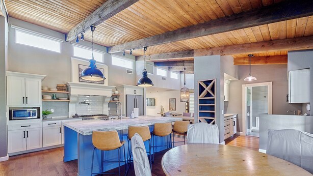 A spacious kitchen with a large island, bar stools, and a round dining table. - Luxury 6 Bed Scottsdale Retreat w/ Pool (Scottsdale)