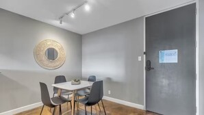Ein Zimmer mit einem runden Tisch, vier Stühlen, einem Spiegel und einer Tür mit einem Schild.