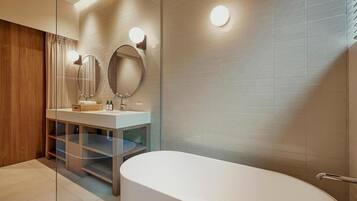Un baño moderno con una bañera independiente, un tocador con espejo y un box de ducha de cristal.