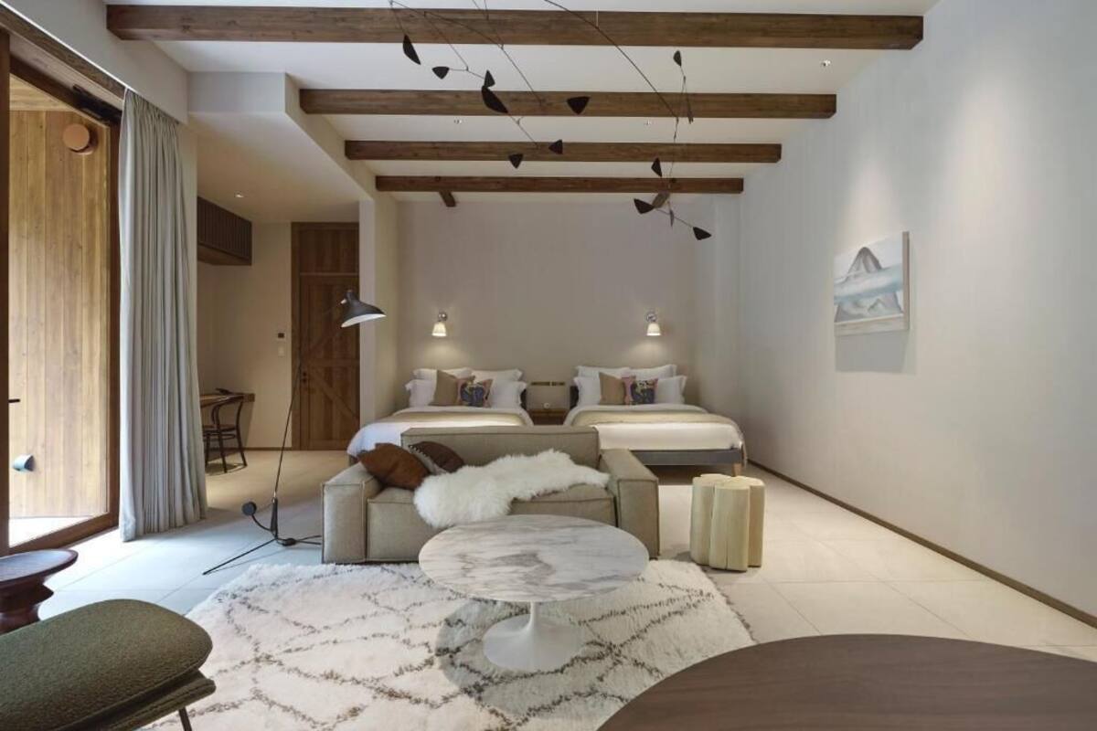 A modern bedroom with a large bed, a sofa, a coffee table, and a desk.