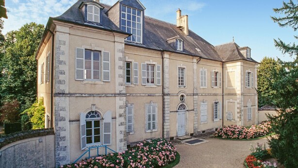 A large, two-story building with multiple windows and a central entrance. - Maison de charme conviviale (Montgivray)