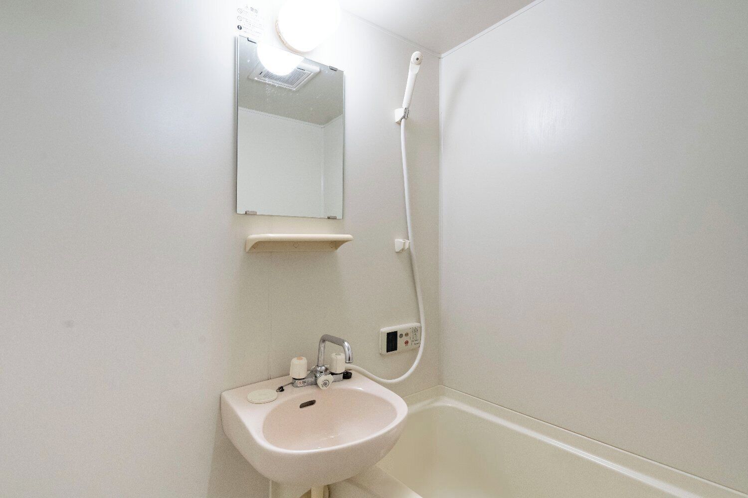 Un baño con lavamanos, espejo y ducha.