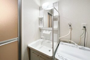 Ein Badezimmer mit Waschbecken, Spiegel und einem weißen Schrank.