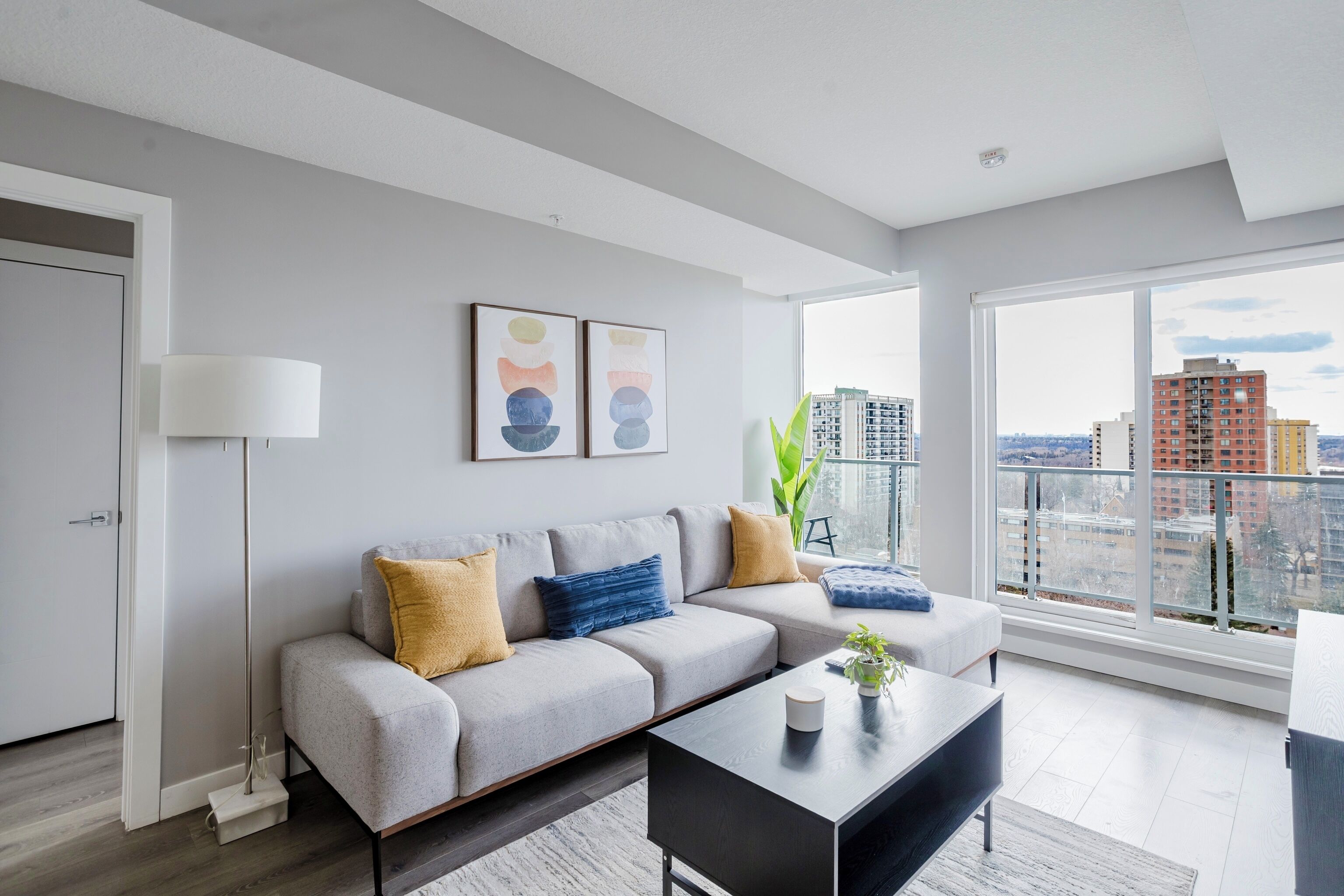 A modern living room with a sofa, coffee table, and artwork on the wall.