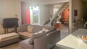 A living room with a sofa, a small table, a lamp, and a staircase leading to a dining area. - Beautiful home in Barneville-Carteret with WiFi (Barneville-Carteret)