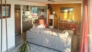 A living room with a sofa, a dining area with a table, and a kitchen with cabinets and appliances. - Beautiful home in Barneville-Carteret with WiFi (Barneville-Carteret)