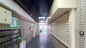 A corridor with lockers, a security camera, and a bicycle in the background. - Mansion Castle (Osaka)