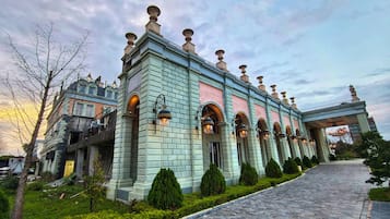 Un edificio histórico con un arco central, ventanas simétricas y un sendero empedrado.
