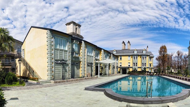 A courtyard with a swimming pool, a staircase, and a building with multiple windows and a balcony. - Napas.manor (Wujie)
