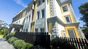 A multi-story building with a symmetrical facade, large windows, and a prominent entrance with a portico. - Napas.manor (Wujie)