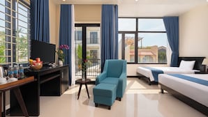 A hotel room with a bed, a sofa, a desk with a TV, and a view of the outside. - Corner Centre Villa Hoi An (Da Nang)