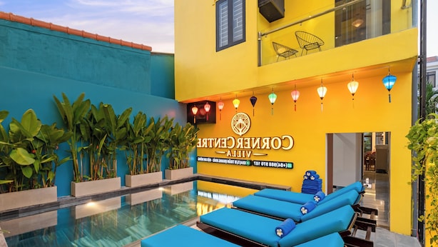 A hotel pool area with lounge chairs and a sign reading 'CORNER CENTRE VILLA.' - Corner Centre Villa Hoi An (Da Nang)