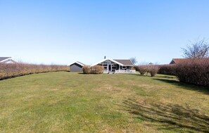 A residential property with a large lawn, a house with a porch, and a shed. - Lovely home in Otterup with sauna (Otterup)