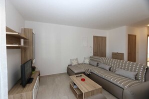 Ein modernes Wohnzimmer mit einer Couch, einem Couchtisch, einem Fernseher und Einbauschränken.
