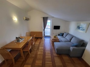 A room with a dining table, chairs, a sofa, a TV, and a window with a view. - Apartment Oly Soline nr 3 (Soline)