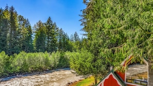 Eine Hütte mit Blick auf einen Fluss, umgeben von dichtem Wald.