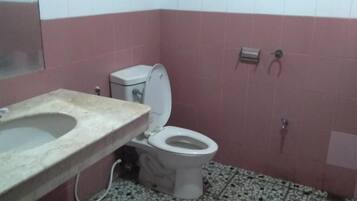 Ein Badezimmer mit Toilette, Waschbecken und Fliesenboden.