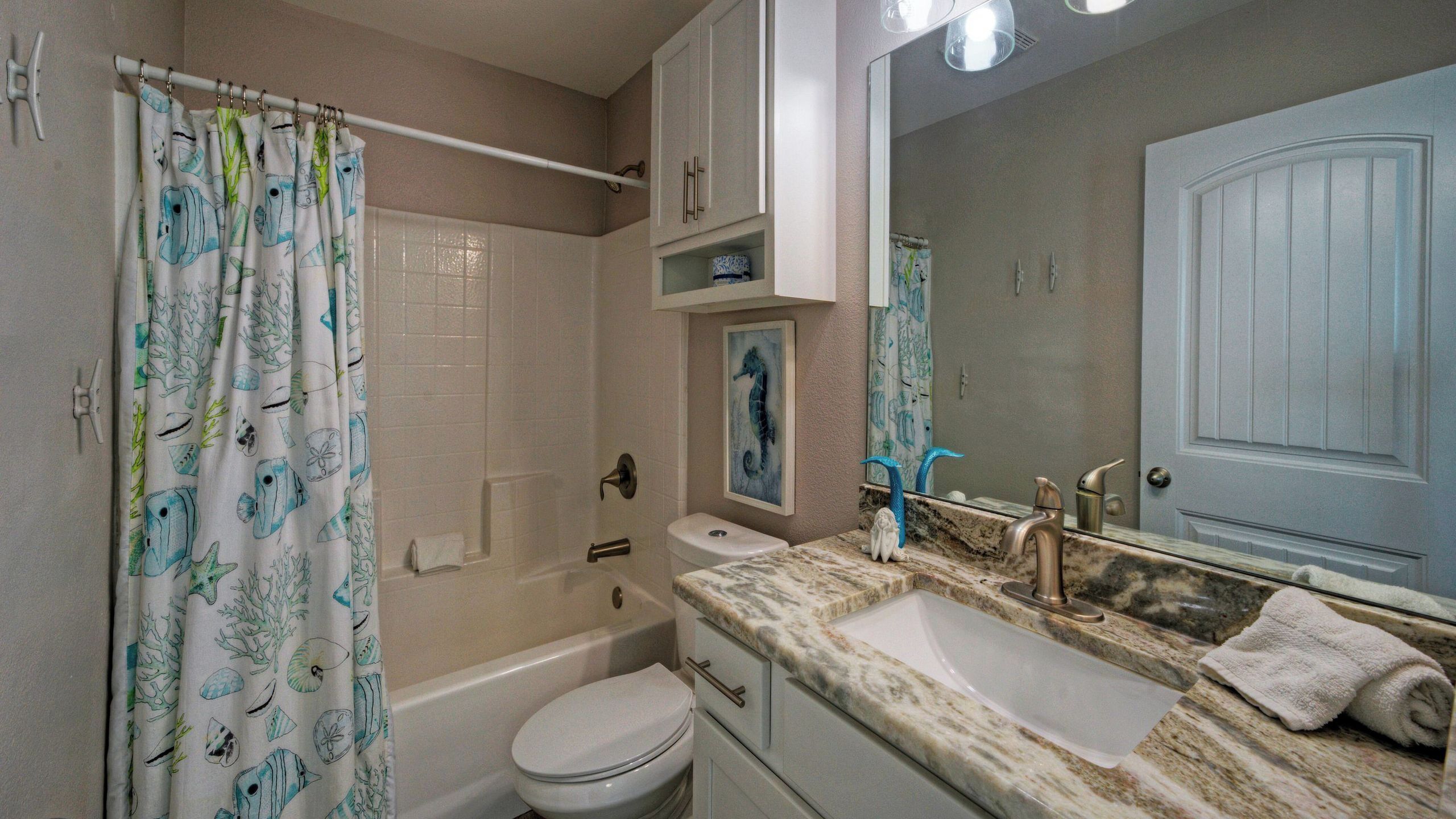 Un baño con bañera, inodoro y dos lavamanos.