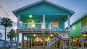 A two-story building with a balcony, wooden deck, and a staircase. - Tickle My Fansea by Avantstay Mins to Shore + Private Pool + Lounge Stylish Beach House (Port Aransas)