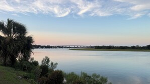 A calm river with a bridge in the distance, surrounded by greenery and trees. - Thunderbolt Coastal Cottage (Thunderbolt)