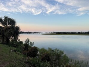 A calm river with a bridge in the distance, surrounded by greenery and trees. - Thunderbolt Coastal Cottage (Thunderbolt)