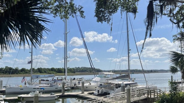 A marina with boats docked, a clear sky, and a calm water body. - Thunderbolt Coastal Cottage (Thunderbolt)