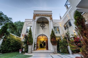 Un edificio imponente con una entrada monumental, un amplio arco y una araña de cristal.