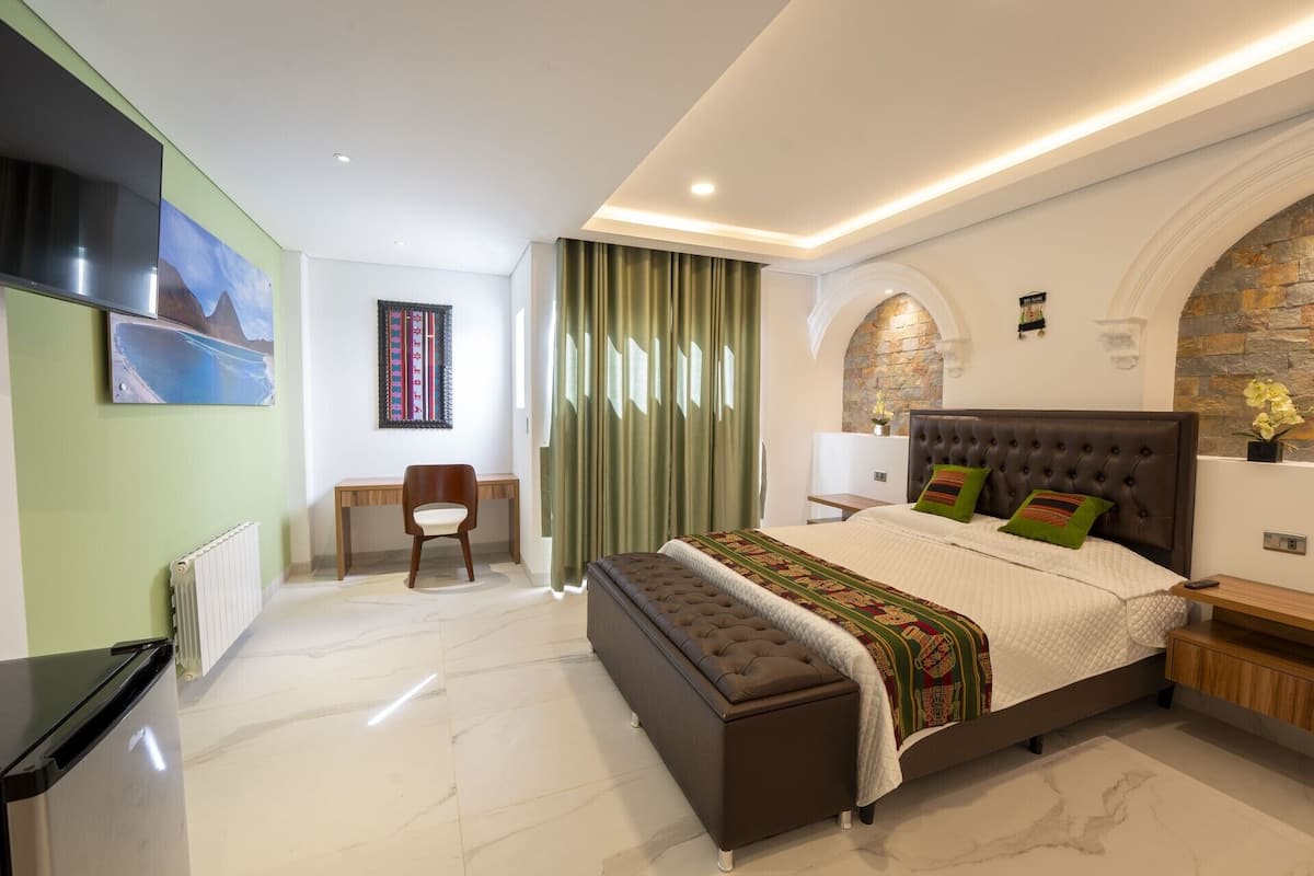 Un dormitorio moderno con una cama grande, un escritorio y una silla.