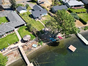 Vue aérienne d’un quartier résidentiel avec des maisons, un quai et une étendue d’eau.