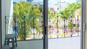 A balcony with a view of a residential area, a small table, and a chair. - Tayga studios Cancun (Cancun)