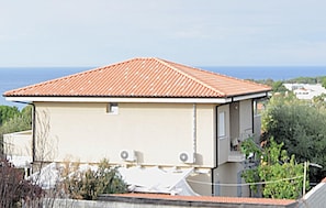 A single-story building with a red-tiled roof, a small window, and a visible satellite dish. - 1 bedroom cozy apartment in Ricadi (Ricadi)