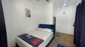 A bedroom with a bed, a painting on the wall, a clock, and a window. - OYO 91303 Chalet Awie (Setiu)