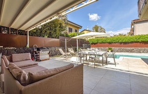 An outdoor patio with a grill, lounge chairs, and a pool. - Nice home in san giovanni la punta (San Giovanni La Punta)