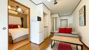 A compact room with a bed, a kitchenette, a sofa, and a dining table. - Lavie Heights (Osaka)