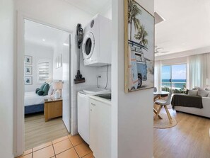 Ein Zimmer mit Bett, Waschmaschine, Essbereich und Meerblick.