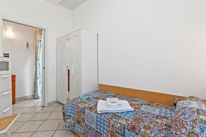 A bedroom with a bed, a chair, a desk, a wardrobe, and a door. - Baia Serena With Terrace & Parking (San Bartolomeo al Mare)