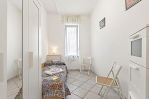 A bedroom with a bed, a chair, a TV, and a window. - Baia Serena With Terrace & Parking (San Bartolomeo al Mare)