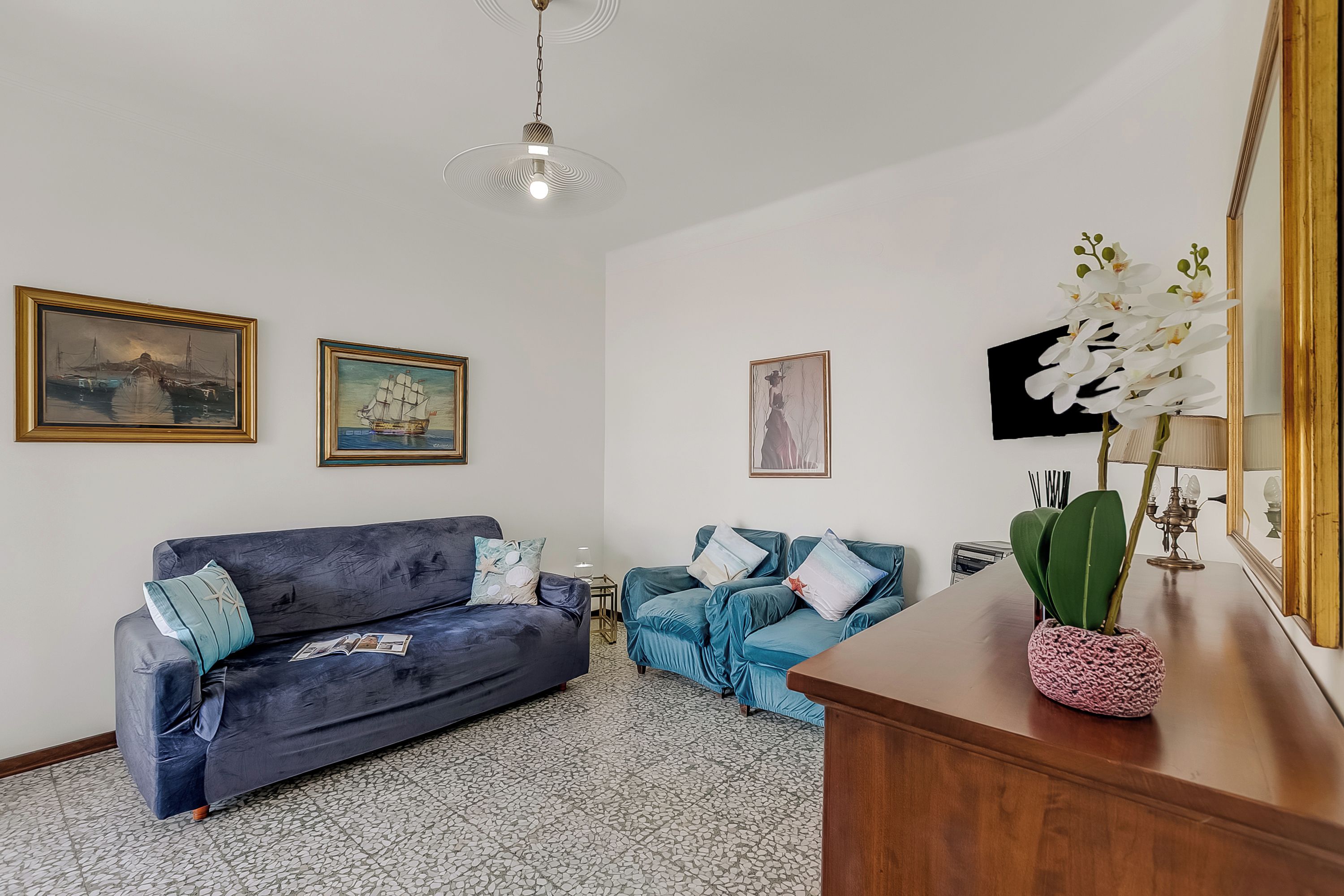Una sala de estar con dos sofás, una mesa de centro de madera y una orquídea en maceta.