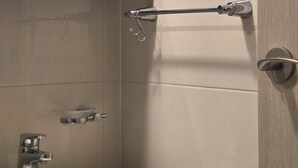Ett badrum med ett vitt handfat, en spegel och en handdukshängare.