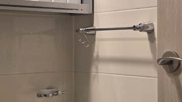 A bathroom with a white sink, a mirror, and a towel rack.
