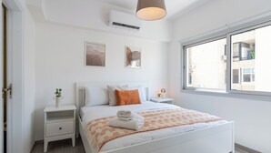 A bedroom with a bed, bedside tables, a window, and wall art. - Hermes 2-BR Apt. & Balcony in Larnaca (Larnaca)